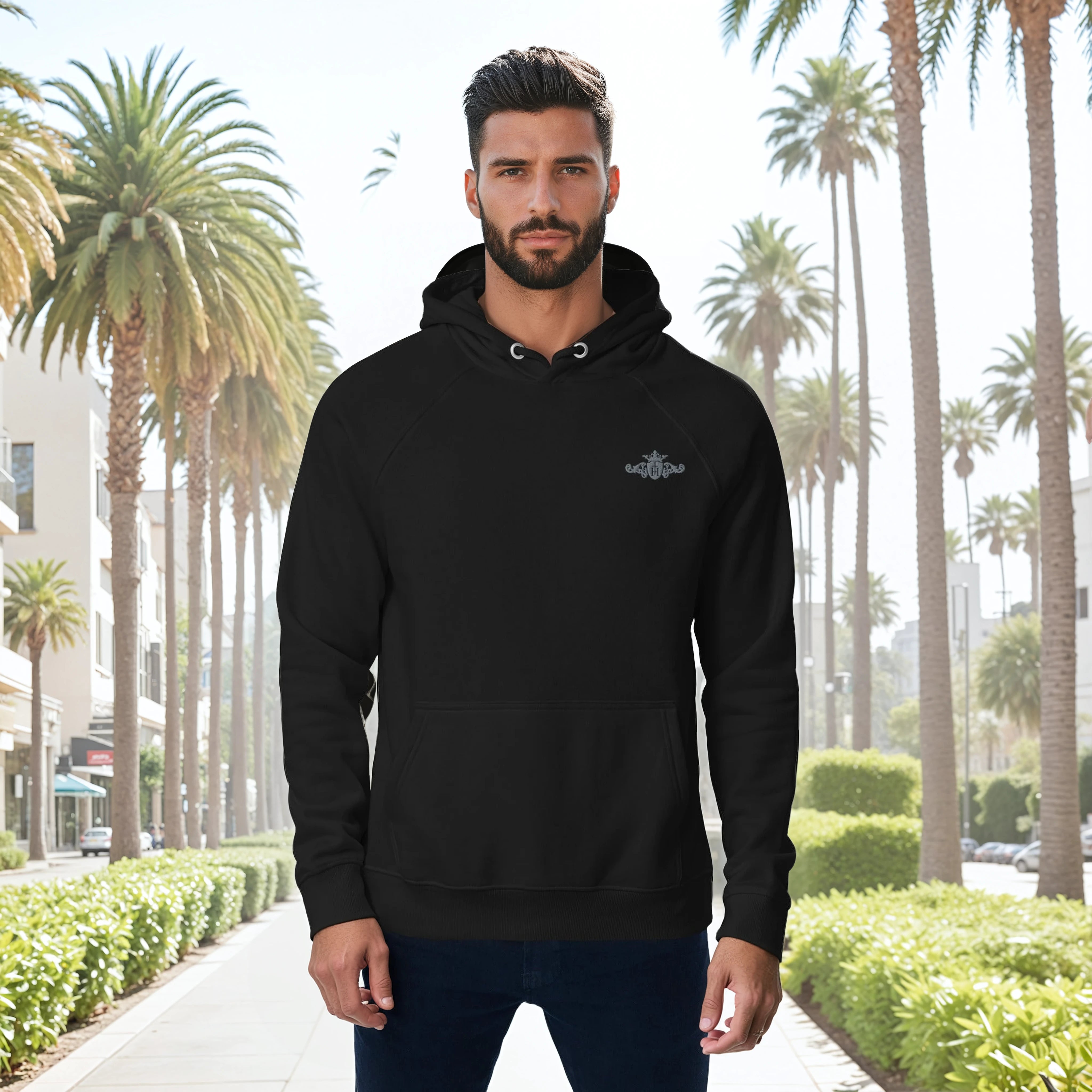 Man wearing a black hoodie with a logo in front of palm trees