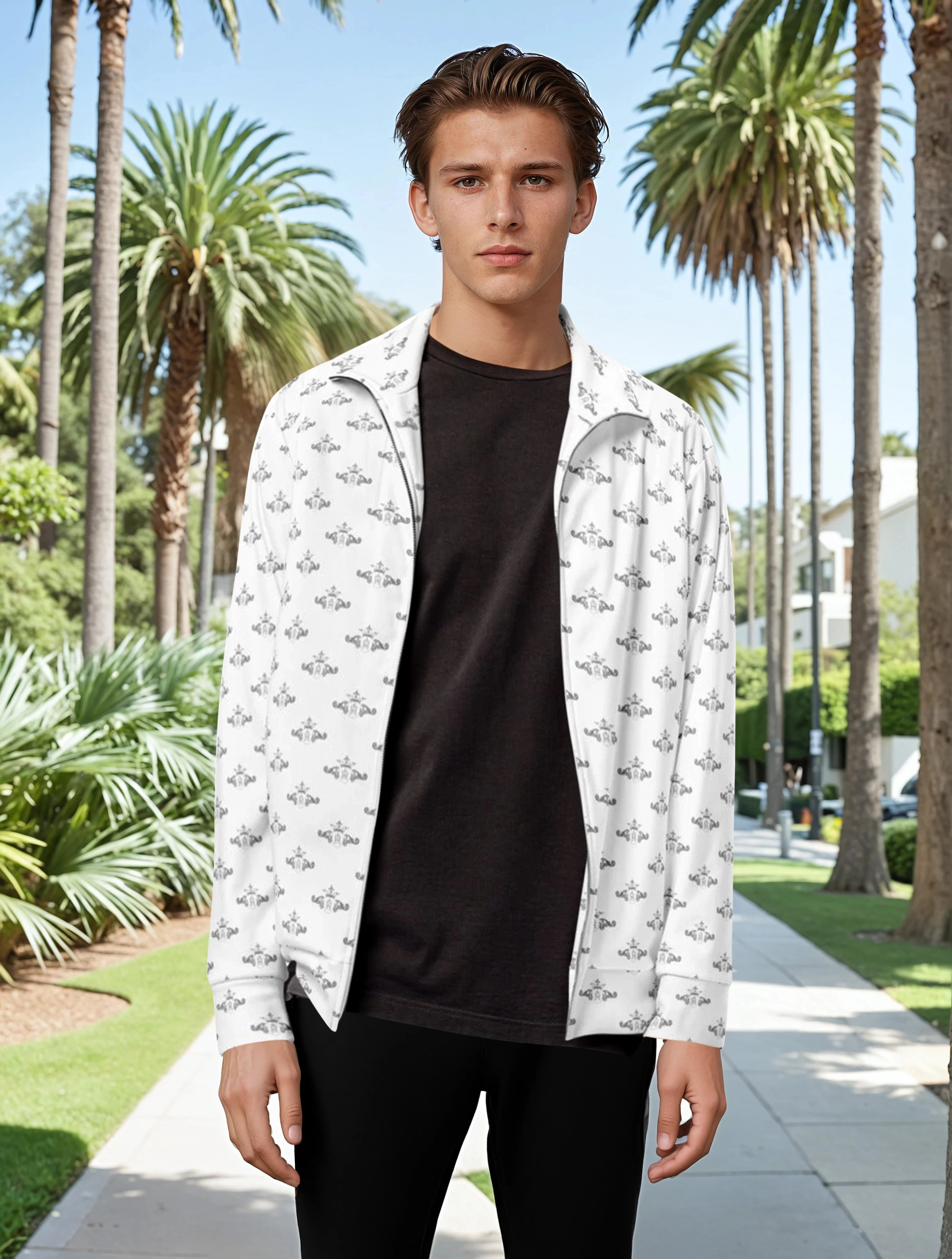 Man wearing a white patterned shirt over a black t-shirt in a park setting with palm trees.
