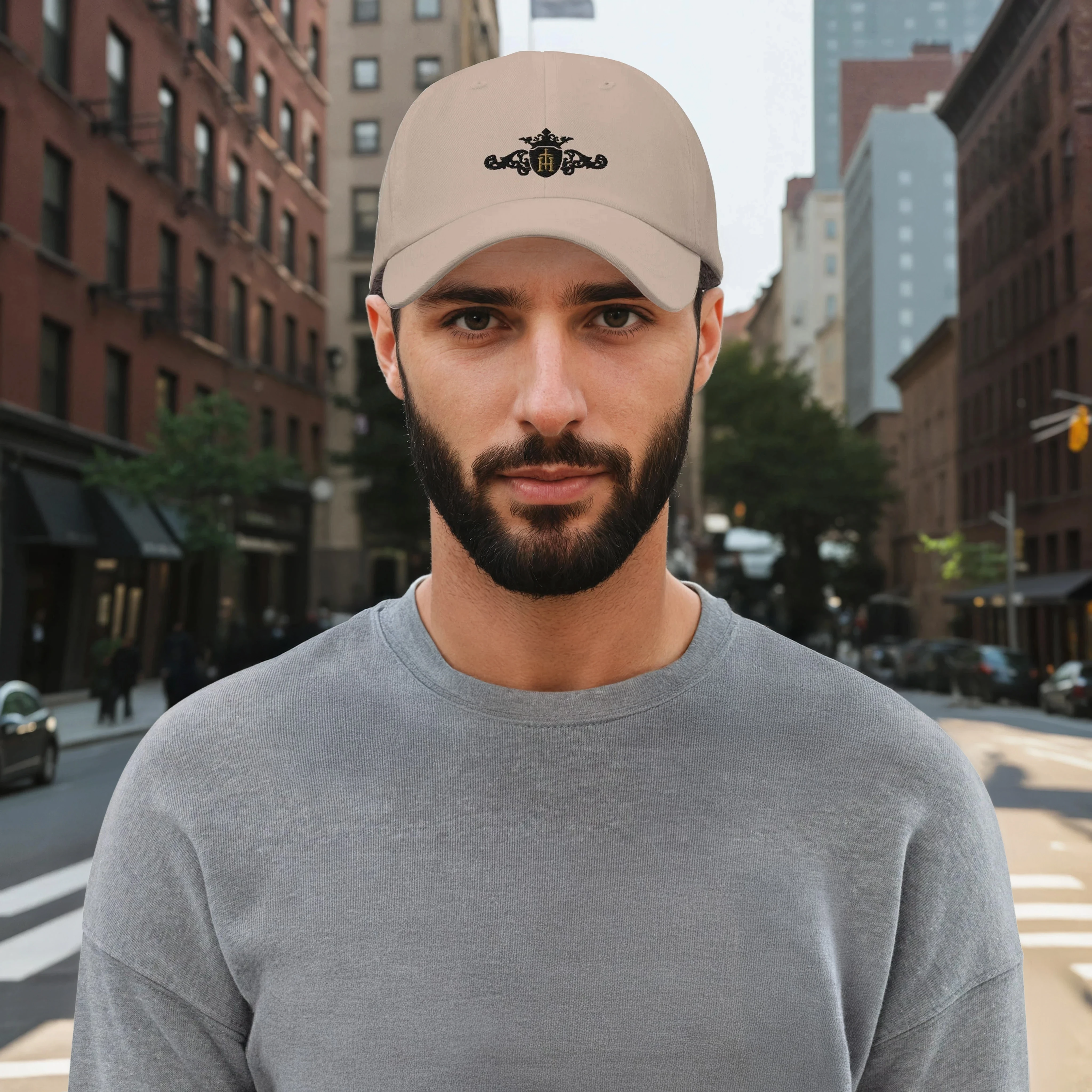 Man wearing a beige cap with a unique crest on a city street