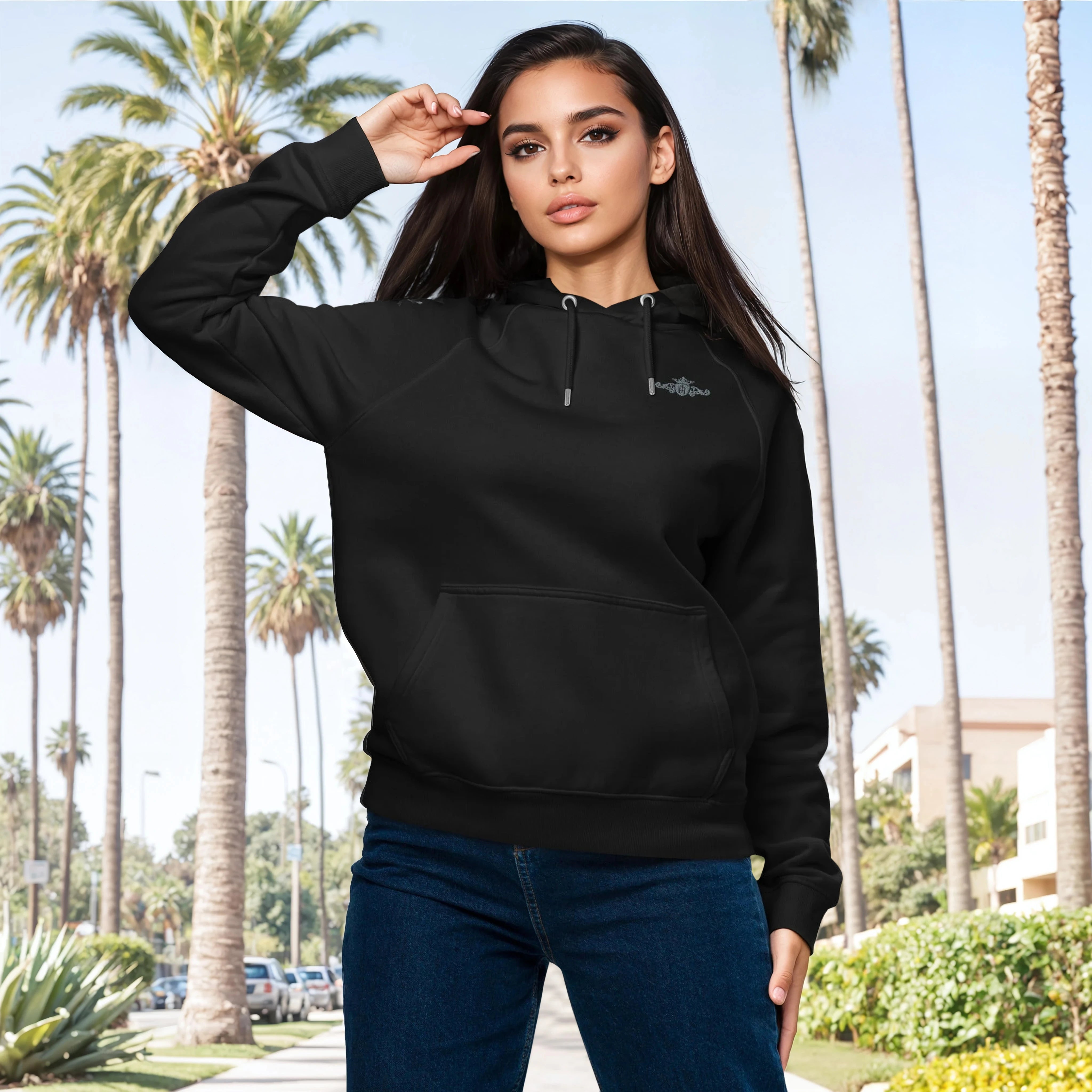 Woman wearing a black hoodie with a palm tree background