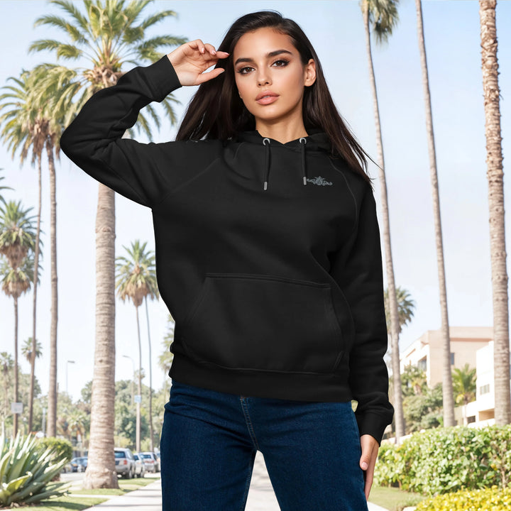 Woman wearing a black hoodie with a palm tree background