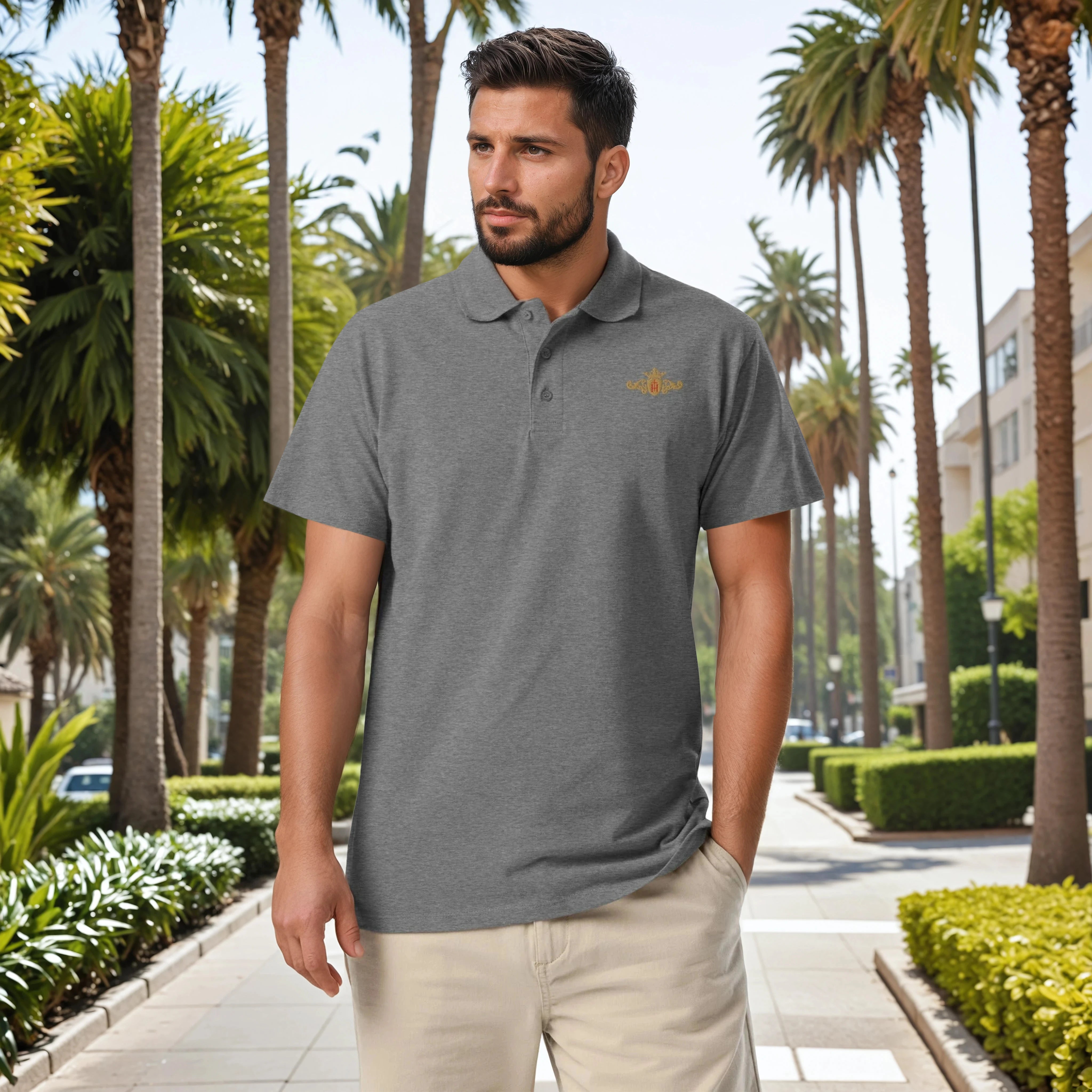 Man wearing a gray polo shirt with a logo in a palm tree-lined street.