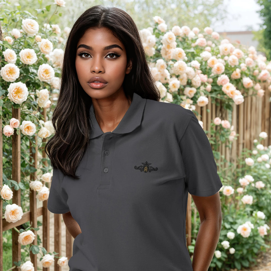 Woman wearing a gray polo shirt with a logo in front of a floral background