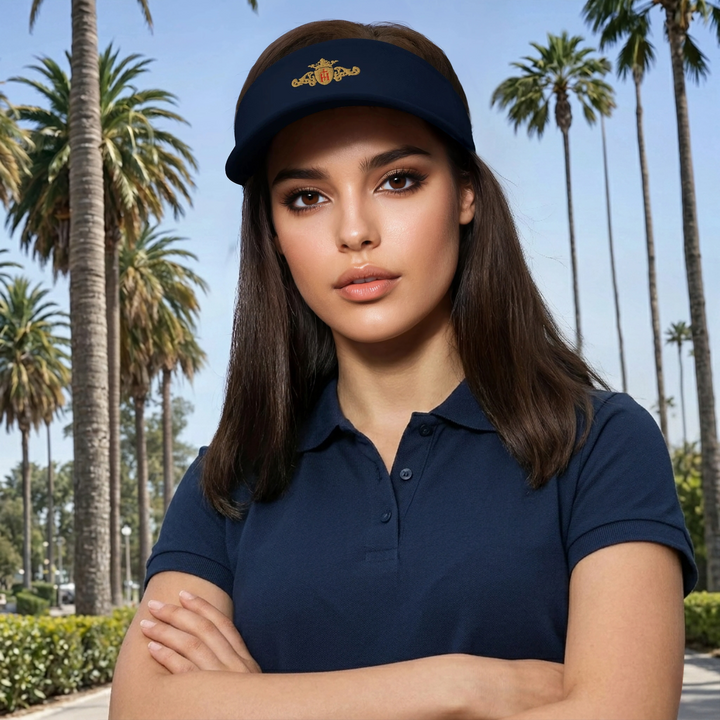 Woman wearing a navy blue polo shirt and visor with palm trees in the background