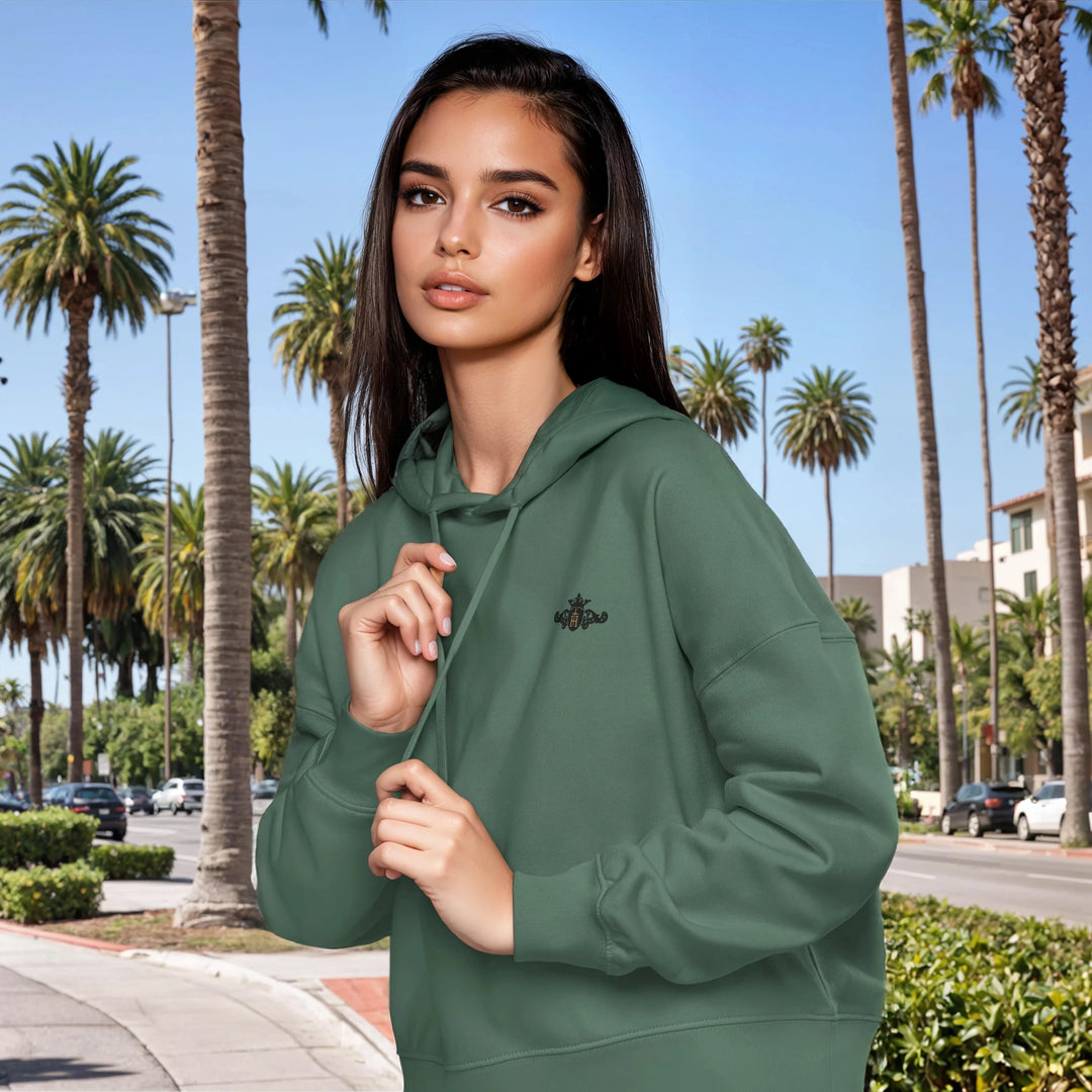Woman wearing a green hoodie with palm trees in the background